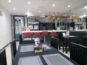 芭东海滩Amici Miei Guest House的一间设有两张桌子的用餐室和一间酒吧