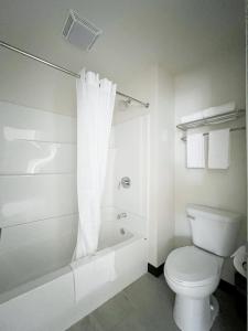 AtlantaThe Trail Inn - Atlanta, Illinois - Route 66, I-55的白色的浴室设有卫生间和淋浴。