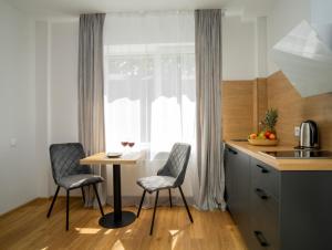 考纳斯Fort63 apartments的厨房配有桌子和两把椅子,设有窗户。