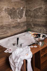 普里什蒂纳Venus Hotel的浴缸、水槽和2杯酒杯