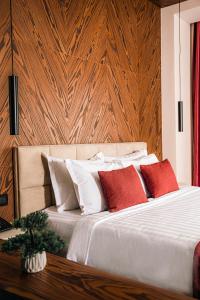 普里什蒂纳Venus Hotel的一间卧室配有红色和白色枕头的床