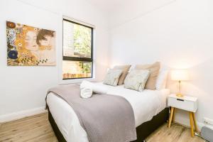 悉尼Crows Nest LemonTree Cozy 3 Bedroom House的白色的卧室设有床和窗户