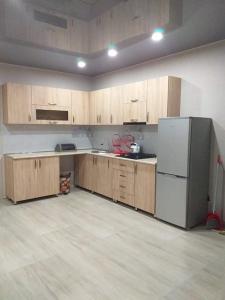 巴库里阿尼Дом гарах的空厨房配有木制橱柜和冰箱