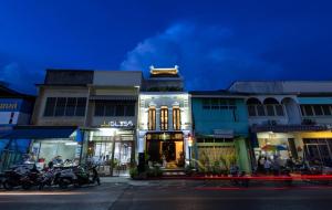 普吉镇Xinlor House - Phuket Old Town的夜幕降临的城市街道上