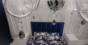 乌拉尔斯克VIP апартаменты однокомнатная квартира的一间卧室配有一张蓝色床头板的床