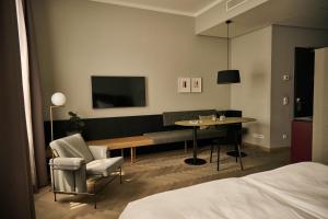 纽伦堡Melter Hotel & Apartments - a Neighborhood Hotel的酒店客房,配有一张床、一张桌子和椅子