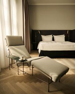 纽伦堡Melter Hotel & Apartments - a Neighborhood Hotel的一间卧室配有一张床、一把椅子和一张桌子