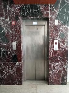 蓬蒂切里Hotel seasons的砖墙中的金属电梯门