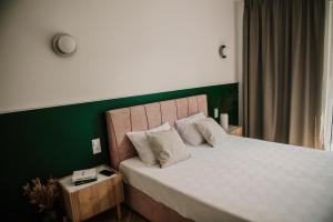比亚沃维耶扎Sam Las Apartamenty Białowieża的一间卧室设有一张大床和绿色的墙壁