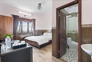 岘港Mộc Nhiên Hotel Da Nang的一间卧室配有一张床,浴室设有水槽