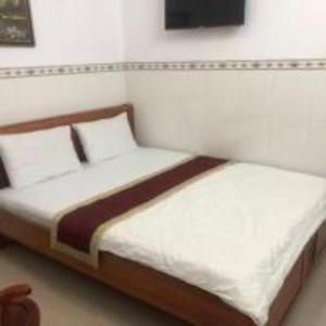 Bến CátHappy 1 Hotel Binh Duong的一间卧室配有带白色床单和枕头的床。