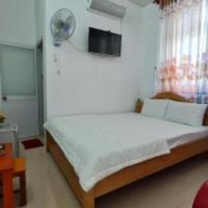 Bến CátHappy 1 Hotel Binh Duong的卧室配有一张大白色的床和风扇