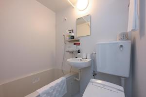 鹿沼HOTEL R9 The Yard Kanuma Sakae的白色的浴室设有水槽和卫生间。