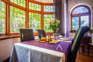 开普敦开普海岸旅馆的用餐室配有带紫色桌布的桌子