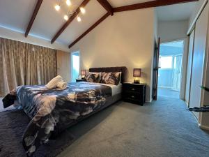 基督城The Airport Homestay House的一间卧室设有一张大床和一个窗户。