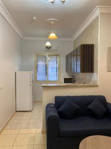 阿哈达منتجع أرين للوحدات السكنية的客厅配有蓝色沙发和冰箱