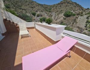 莫哈卡尔TRIPLEX DE LUJO EN MOJACAR的山景阳台上的粉红色长凳