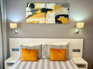 诺哈拉斯奥拉斯酒店的一间卧室配有带两个枕头的床和一幅画