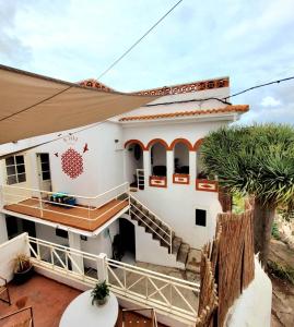 FirgasACORAN FAMILY的带阳台和棕榈树的白色房屋