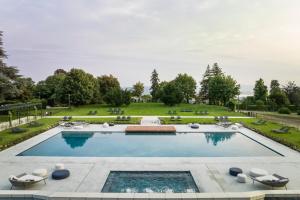 瓦雷泽瓦雷赛皇宫大酒店的一个带草坪和树木的大型游泳池