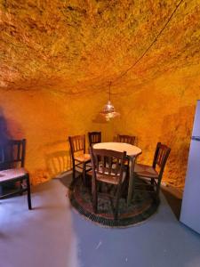 FirgasACORAN FAMILY的一间位于洞穴内的带桌椅的用餐室