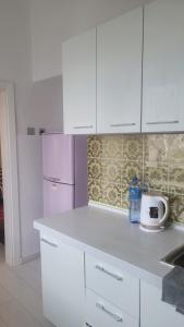 乌兰巴托A nicely furnished, cozy apartment located in the center的厨房配有白色橱柜和紫色冰箱