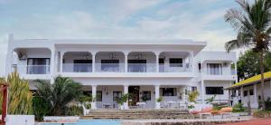 马林迪Met Beach Resort Malindi的一座白色的房子,前面设有一个游泳池