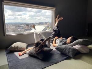 京都Kamogawa Building 9th Floor-1 - Vacation STAY 41867v的两个女孩躺在窗前的枕头上