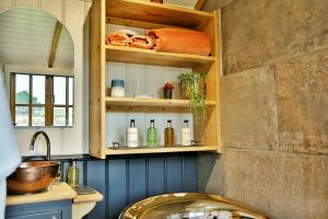 杜伦The Garden Rooms at Lonton的厨房配有水槽和带瓶子的架子
