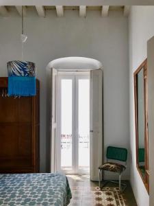 加的斯Apartamentos La Selva的一间卧室设有一张床、一个窗口和一把椅子