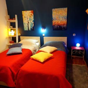 卢卡兰Holiday house "LEA"的一间卧室设有两张带红色床单和蓝色墙壁的床。
