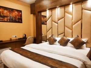 TezpurHotel Friends Palace的卧室配有一张白色大床和木制床头板