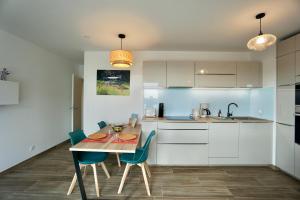 拉福雷富埃南L'Escale的厨房配有木桌和蓝色椅子