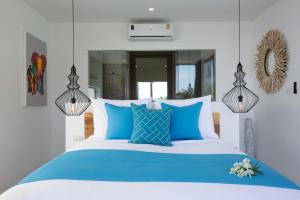 苏梅岛Zog Villas的一间卧室配有蓝色和白色的床和蓝色枕头