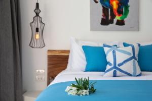 苏梅岛Zog Villas的一间卧室配有一张蓝色的床,床上有鲜花