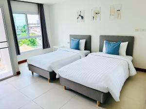 曼谷The Lodge @ Min Residence的两张睡床彼此相邻,位于一个房间里