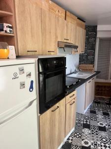Saint-Jean-sur-MayennePetite maison sympa的厨房铺有黑白地板,配有白色冰箱。