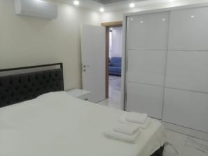 代姆雷Deniz Apart的白色卧室设有床铺和玻璃淋浴间