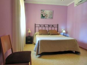 帕尔斯堪巴赛里斯旅舍的一间卧室配有一张紫色墙壁的床和一把椅子