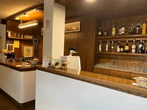 圣卡特琳娜瓦尔夫Hotel Alle Tre Baite的酒吧配有带玻璃杯和酒瓶的吧台