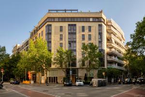 巴塞罗那美国巴塞罗纳酒店的一条城市街道上的建筑,前面有汽车停放