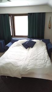 海门林纳Talo uima-altaalla的卧室配有一张大白色床和窗户