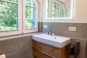 博恩Lieblingshof的一间带白色水槽的浴室和两个窗户