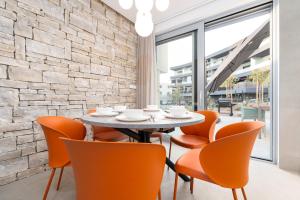 克尔克Luxury semi detached villa Smokva 2 - near center and sea - by TRAVELER tourist agency Krk的一间带桌子和橙色椅子的用餐室