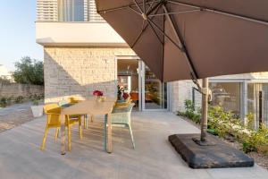 克尔克Luxury semi detached villa Smokva 2 - near center and sea - by TRAVELER tourist agency Krk的庭院配有桌椅和遮阳伞。