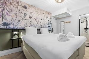 阿姆斯特丹Dutch Design Hotel Vondelpark的卧室配有一张白色大床和花卉墙