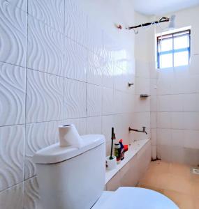 马查科斯Mileslin Homes的白色的浴室设有卫生间和水槽。