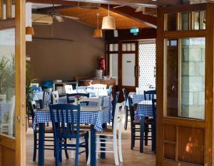 帕福斯大殿假日度假胜地酒店的一间配备有蓝白色桌椅的用餐室