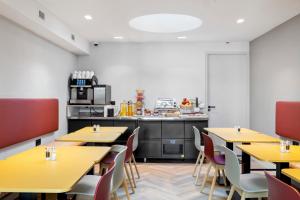阿姆斯特丹Dutch Design Hotel Vondelpark的一间带黄色桌椅的餐厅和一间厨房
