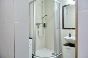 巴德加斯坦Haus Nicola的带淋浴和盥洗盆的白色浴室